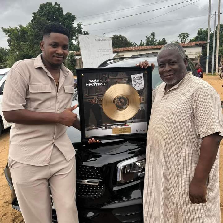 Tamsir Honore Son Mentor Bomou Bassa en Lui Présentant Son Disque d’Or Tamsir Honore Son Mentor Bomou Bassa en Lui Présentant Son Disque d’Or